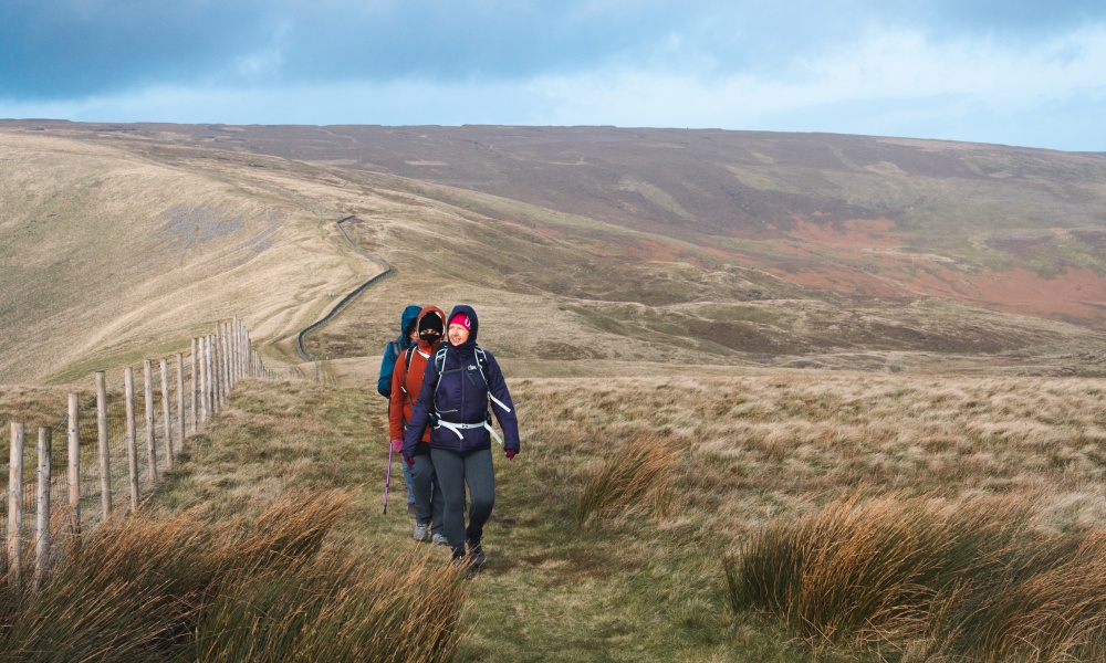 A walking group journeying on a vast, empty moorland