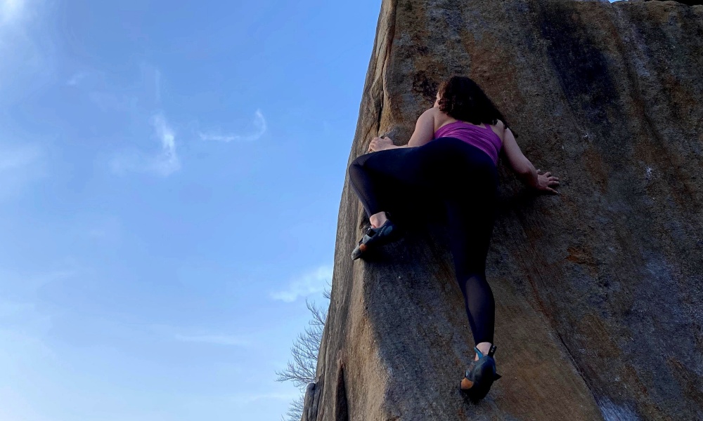 Darcey Haddow bouldering on an arete outdoors